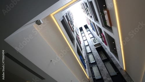 Under view of moving elevators and many stories in modern big hotel photo