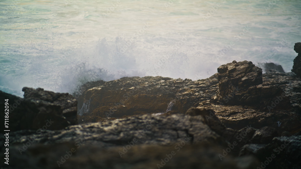 Sea waves hitting rocks making explosion closeup. Storm water foaming breaking Sea waves hitting rocks making explosion closeup. Storm water foaming breaking