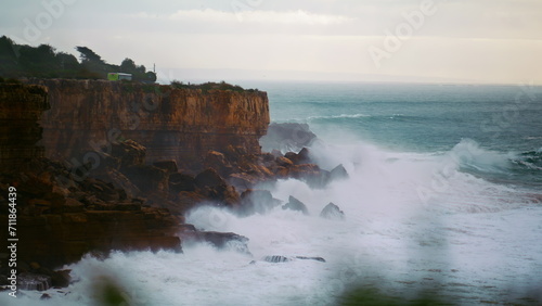 Stormy ocean breaking cliffs in slow motion. Powerful waves crashing wild rocky