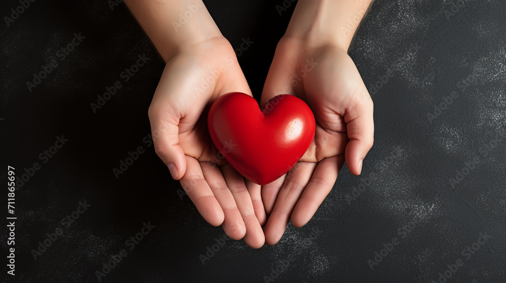 Top view photo of hands holding red heart on black background, healthcare, love, organ donation, mindfulness, wellbeing, family insurance and CSR concept, World Heart Day. Top view photo of hands holding red heart on black background, healthcare, love, organ donation, mindfulness, wellbeing, family insurance and CSR concept, World Heart Day.