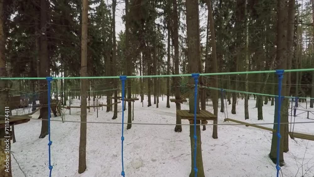 Obstacle course with wooden bridges on ropes in snowbound forest Obstacle course with wooden bridges on ropes in snowbound forest