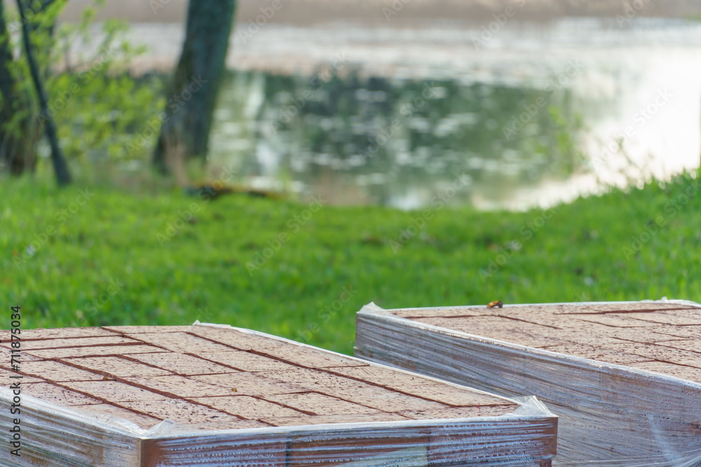 Fototapeta premium Laying paving slabs on a construction site. Repair of a road or sidewalk. The new paving slabs are neatly stacked in boxes.
