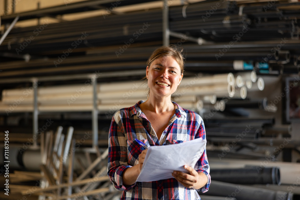 Obraz premium Woman supervisor checking quality of production at hardware store warehouse