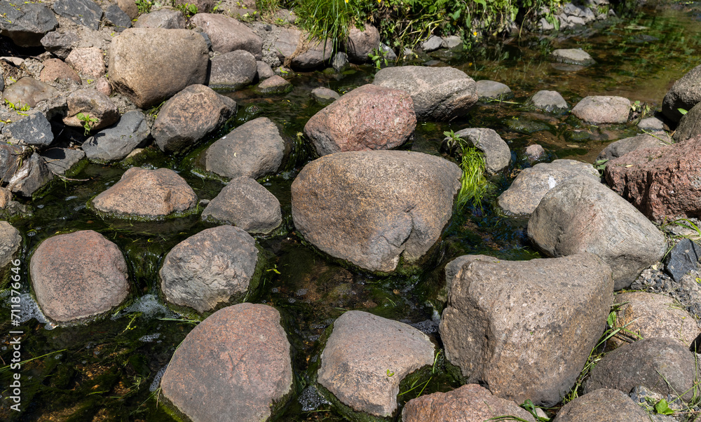 water flowing in a small narrow stream in summer water flowing in a small narrow stream in summer