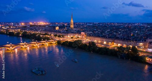 Picturesque view from drone of illuminated modern cityscape of French port city of Bordeaux on river Garonne and Stone Bridge photo