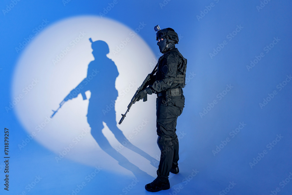 Soldier in black uniforms with weapon in studio, man full length photo. Concept Military warrior army tactical force to fight crime in city Soldier in black uniforms with weapon in studio, man full length photo. Concept Military warrior army tactical force to fight crime in city