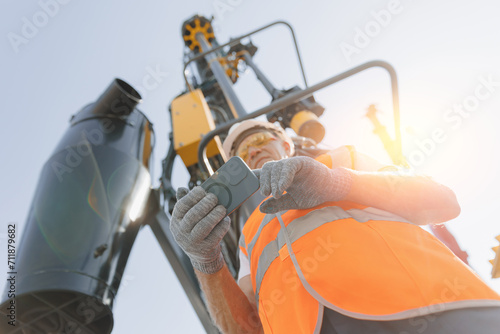 Modern technology of Industry. Operator use mobile tablet for control drilling rig for exploration of minerals for oil, gas and artisan water