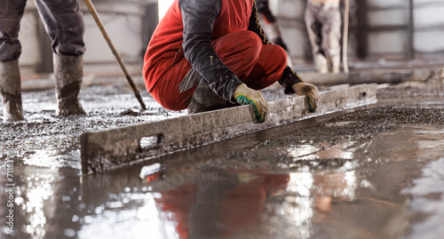 Workers work on concrete concreting floors of buildings in construction site, pouring cement