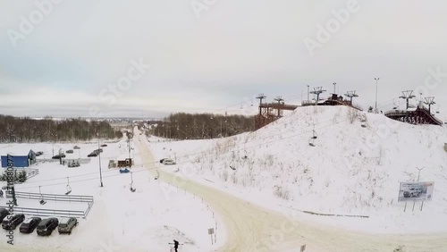 Skiing resort with chairlift on small hill covered by snow photo