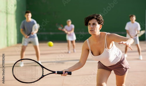 Latin woman playing frontenis on outdoor pelota court during training. Woman playing Basque pelota speciality. photo