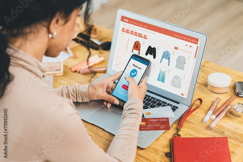 Woman shopping online on internet marketplace browsing for sale items for modern lifestyle and use credit card for online payment from wallet protected by crucial cyber security software photo