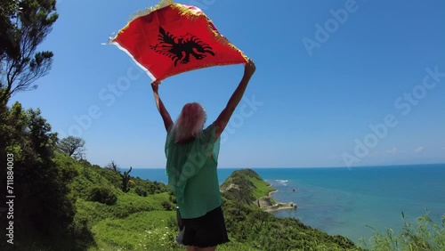 Woman with Albanian flag on Cape of Rodon in Albania. A tranquil beach along the cape provides opportunities for relaxation, swimming and sunbathing. photo