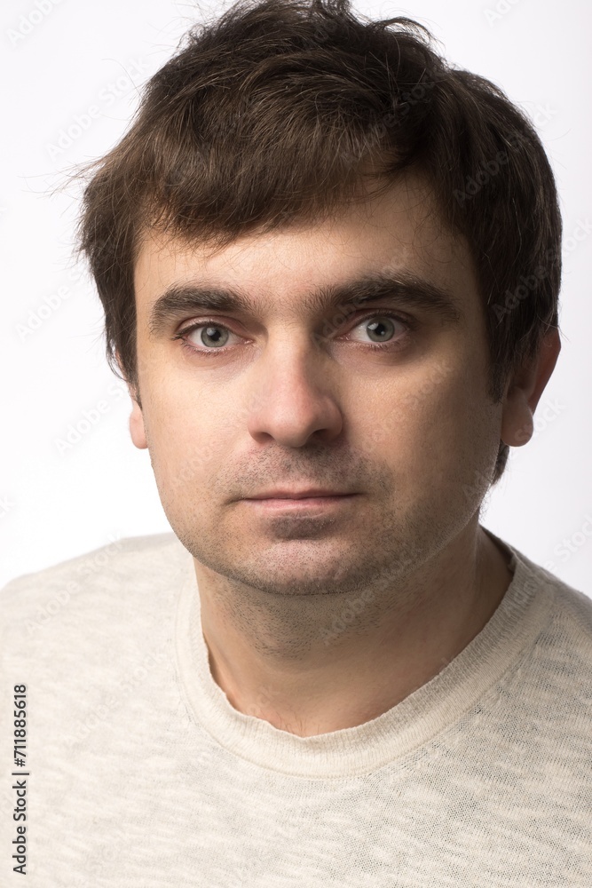 Portrait of a man with a neutral expression, wearing a light beige sweater. The subject is in focus with a plain white background, offering a professional and clean look, ideal for stock use Portrait of a man with a neutral expression, wearing a light beige sweater. The subject is in focus with a plain white background, offering a professional and clean look, ideal for stock use