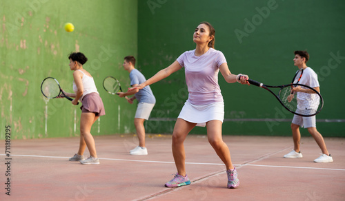 Sportive woman in shorts and t-shirt playing frontenis on outdoors court © JackF