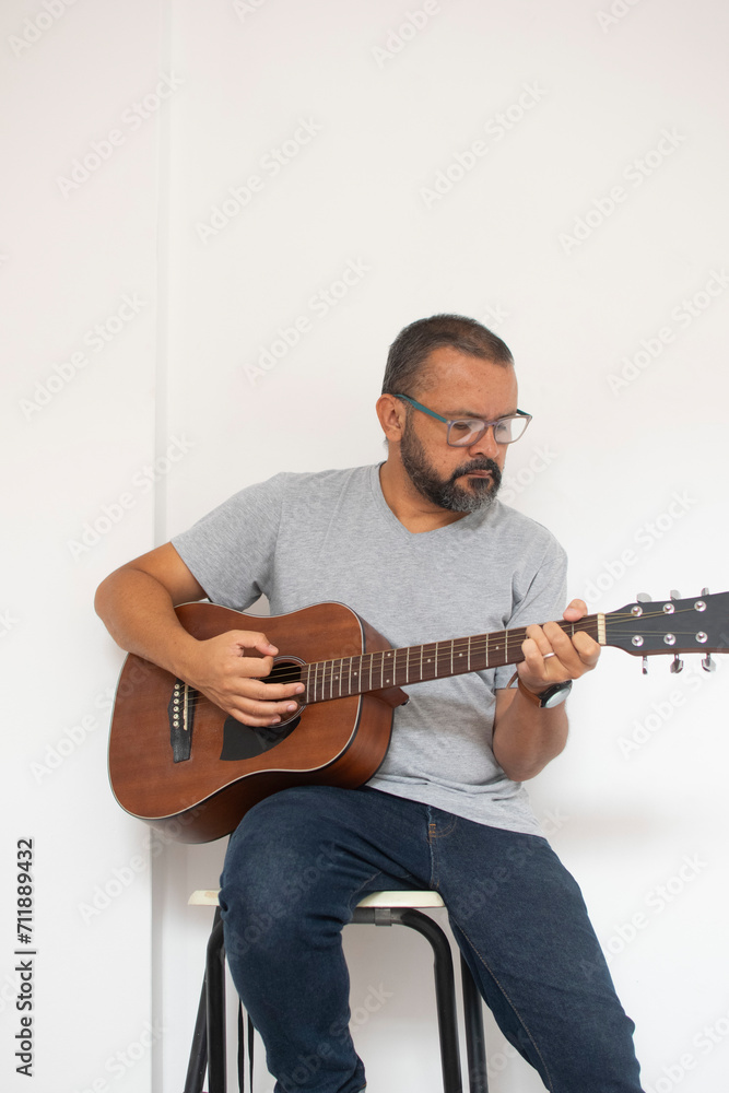 Aesthetic photo of an attractive, bearded hipster playing acoustic guitar outdoors at sunset.  acoustic guitar. Teacher.