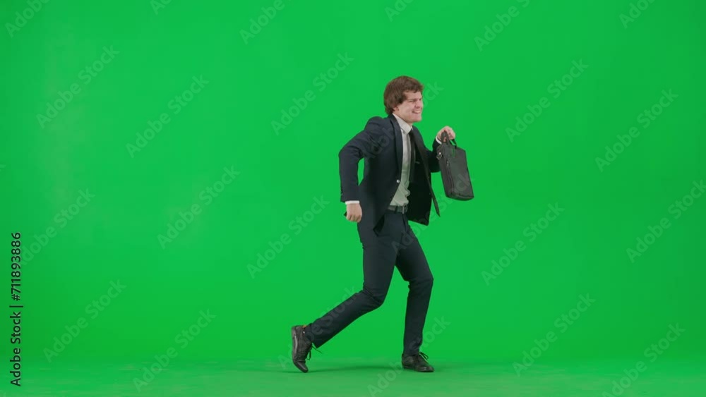 Portrait of male model in suit on chroma key green screen. Handsome young businessman in trendy suit holding briefcase and starts dancing Portrait of male model in suit on chroma key green screen. Handsome young businessman in trendy suit holding briefcase and starts dancing