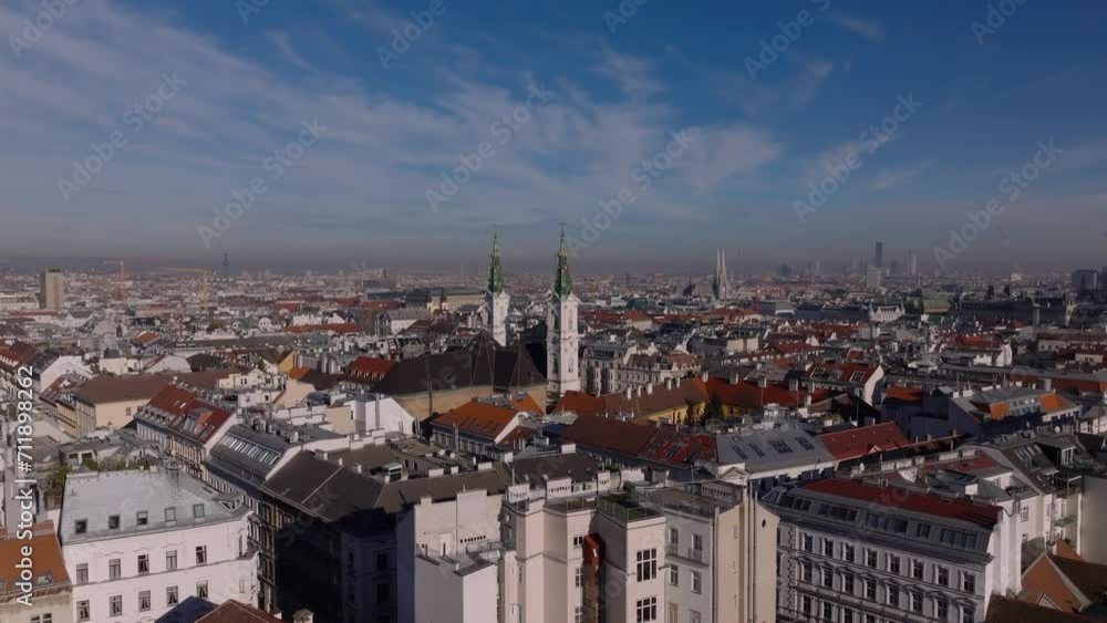 Aerial ascending shot of Piarist Church surrounded by town development in residential urban borough. Old multistorey apartment houses in city. Vienna, Austria Aerial ascending shot of Piarist Church surrounded by town development in residential urban borough. Old multistorey apartment houses in city. Vienna, Austria