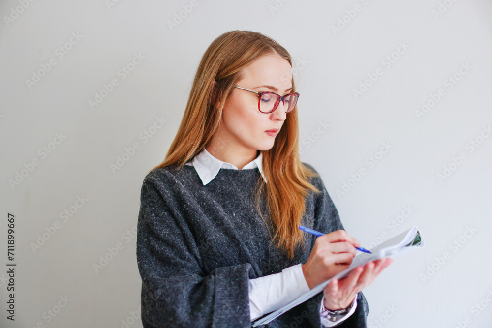 female secretary or business assistant holding pen and clipboard, looking at camera and smiling female secretary or business assistant holding pen and clipboard, looking at camera and smiling