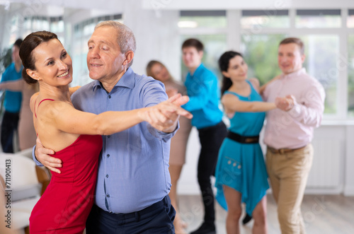 Adult woman and old man dancing in dance class © JackF