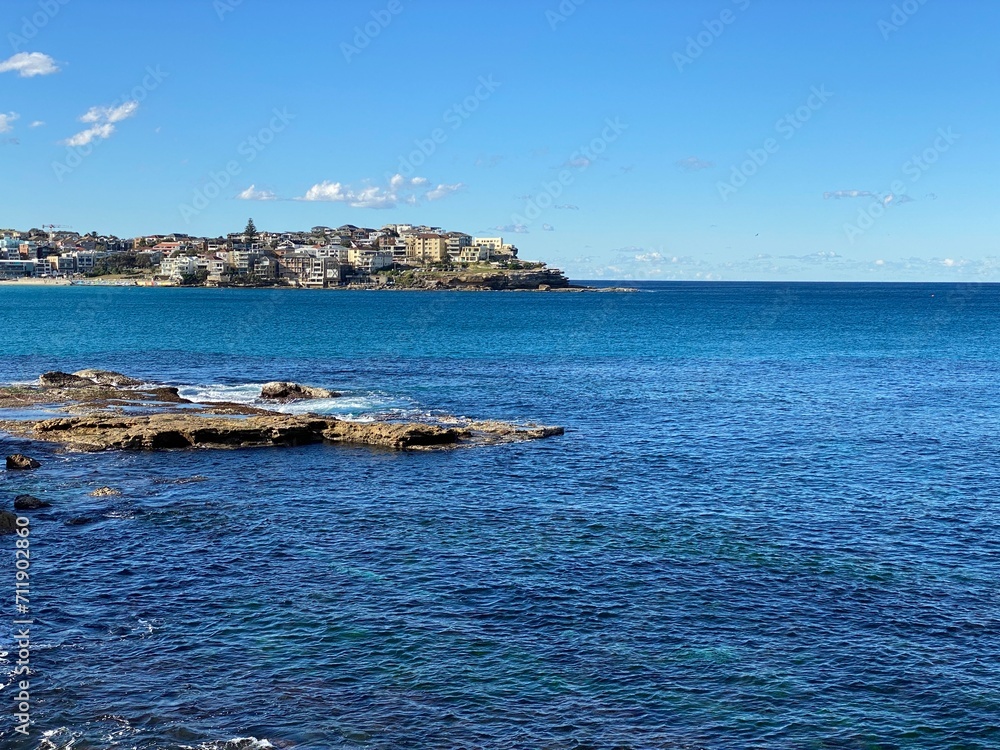 Coast of the ocean. View of the city in the distance surrounded by water. Landscape and shore. Australia.