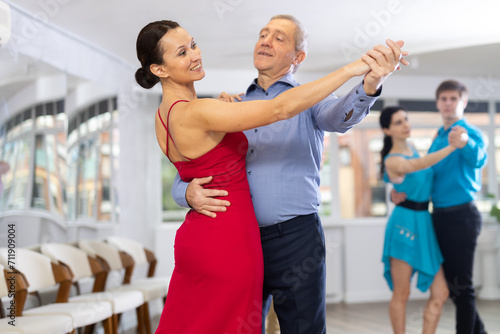 Pair dances - men and women in festive attire dance tango or samba