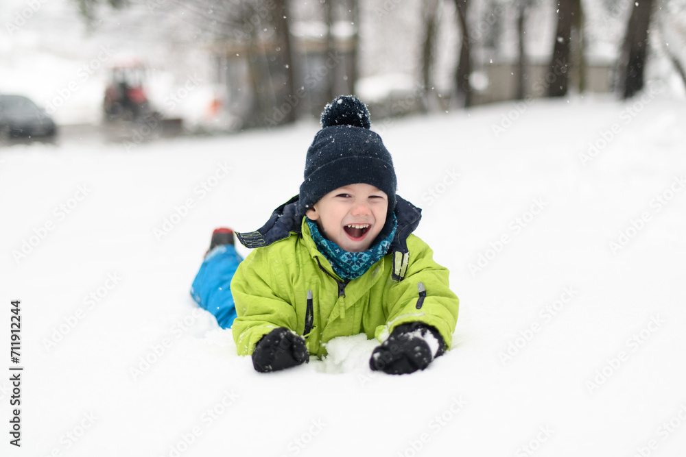Portrait of Little Happy Boy Lies in Snow Portrait of Little Happy Boy Lies in Snow
