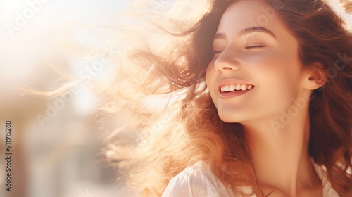Young beautiful woman with natural makeup in the sunlight. Happy lady enjoying the sun. Banner with copy space. Ideal for beauty, wellness, lifestyle campaigns or hair care advertisements. photo