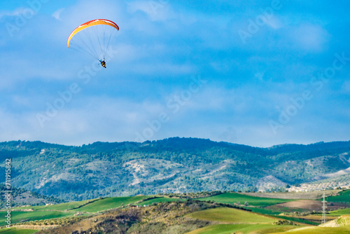 Paraglider flying over spanish nature landscape in Andalucia.