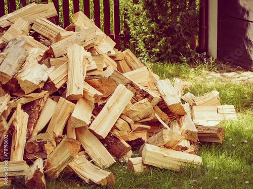 Stack of firewood on green grass.