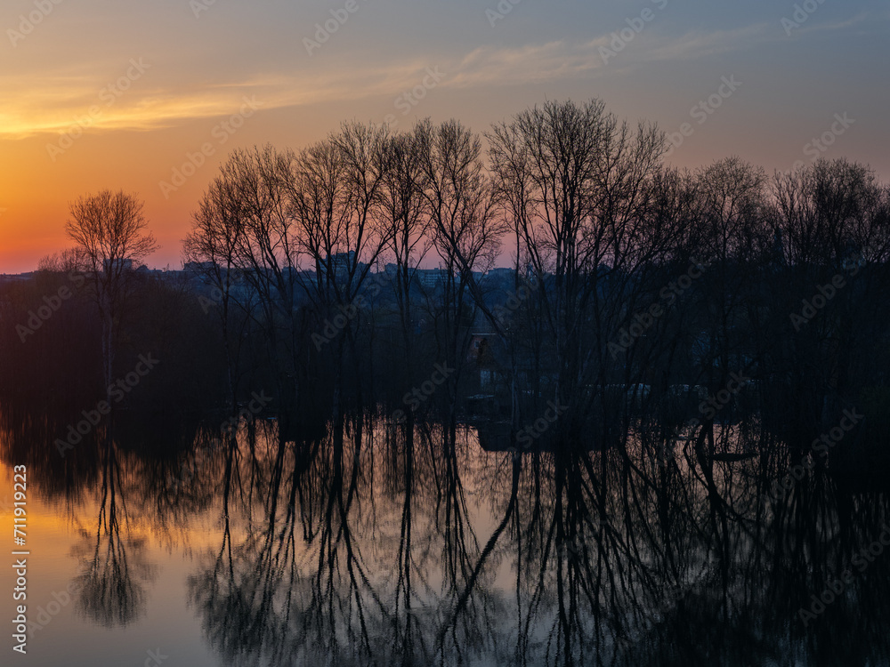 Spring flood, sunset landscape with flooded trees and reflection in the ...