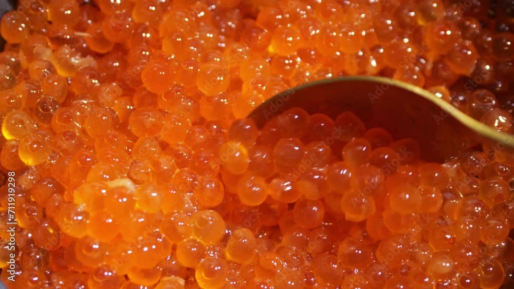 Salmon caviarand a golden spoon. Red caviar background. Gourmet food up close. Seafood and delicatessen. closeup Salmon caviarand a golden spoon. Red caviar background. Gourmet food up close. Seafood and delicatessen. closeup