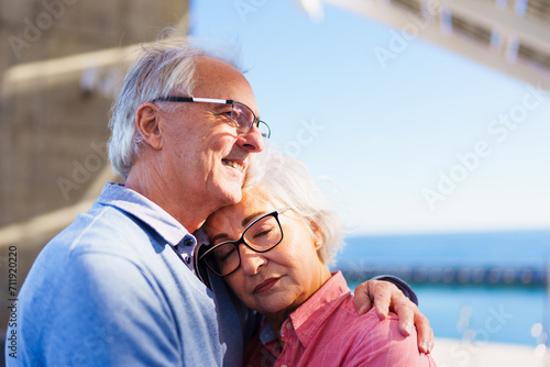 Tender scene of a senior couple embracing under the sun in the city