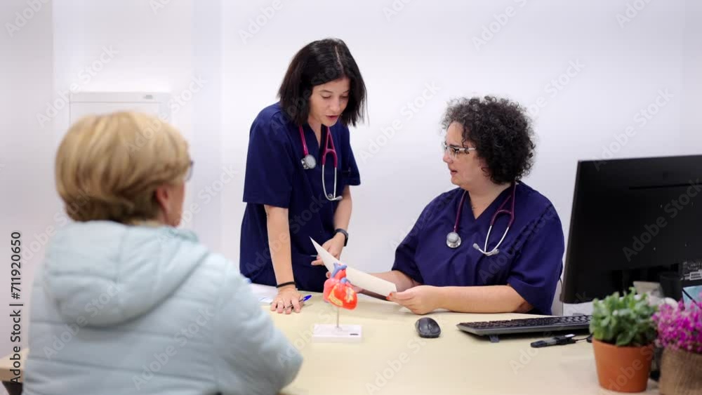 Video of a nurse entering to a cardiologist office while attending an old woman Video of a nurse entering to a cardiologist office while attending an old woman