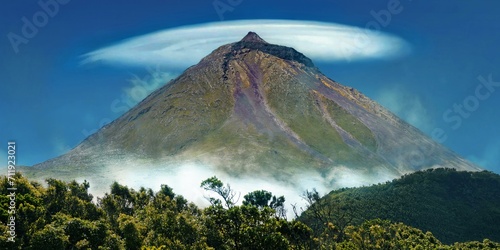 Pico volcano with a lenticularis cloud in the blue sky, surrounded by vegetation, Gruta das Torres, Pico Island, Azores, Portugal, Europe