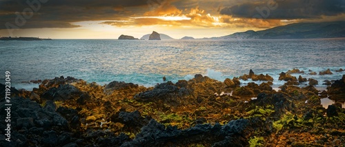 Dramatic volcanic coastal landscape at sunset with glowing sky and cliffs, Madalena, Pico, Azores, Portugal, Europe photo