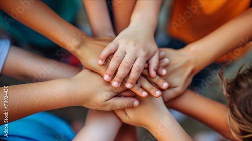 Kids stacking their hands  symbolizing teamwork and camaraderie in a kindergarten group collaboration and unity among young children.