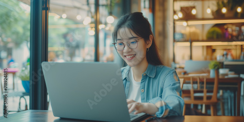 a smiling young woman working on her laptop