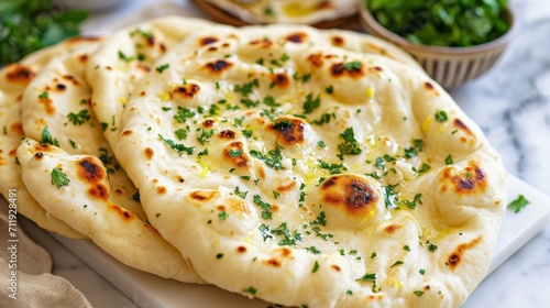 indian naan bread with herbs and garlic seasoning on plate photo