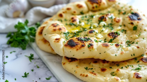 indian naan bread with herbs and garlic seasoning on plate,close up photo