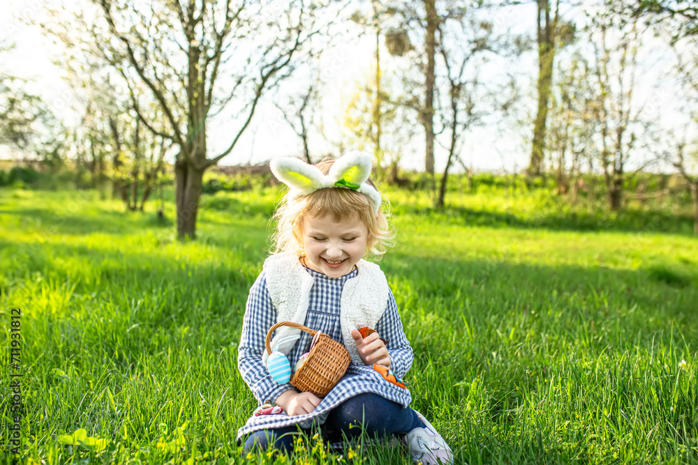 Little girl smiling happily wearing Bunny ears Easter egg hunt in garden Little girl smiling happily wearing Bunny ears Easter egg hunt in garden