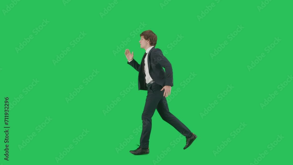 Profile view of male model in suit isolated on chroma key green screen background. Positive young businessman in blue suit running fast. Profile view of male model in suit isolated on chroma key green screen background. Positive young businessman in blue suit running fast.