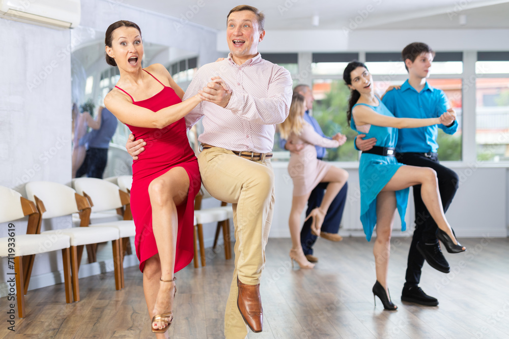 Fototapeta premium Dynamic pair engaging in Latino dance in dance studio. Pairs training ballroom dance in hall