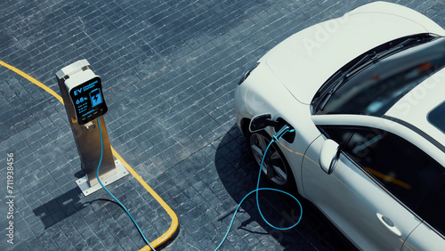 Schilderij op canvas Aerial view electric car recharging battery from EV charging station at city center public car park