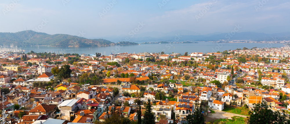 Scenic aerial view of modern cityscape of Fethiye along shoreline of Aegean Sea on sunny winter day, Turkey