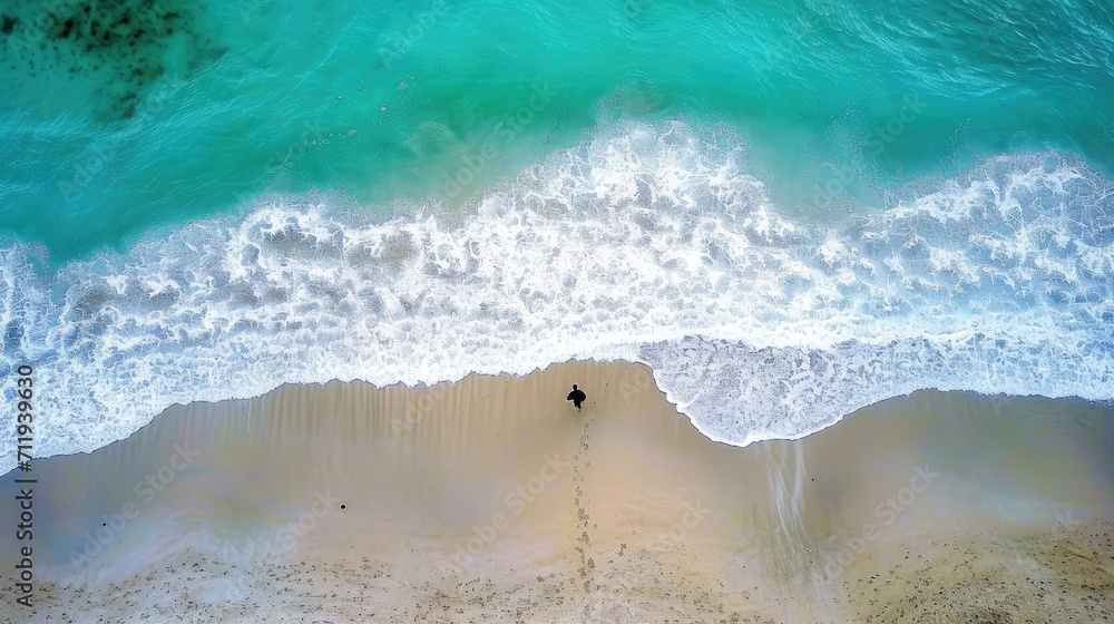aerial view of a beautiful beach with blue waves coming to shore, one man standing alone on the beach,  backdrop