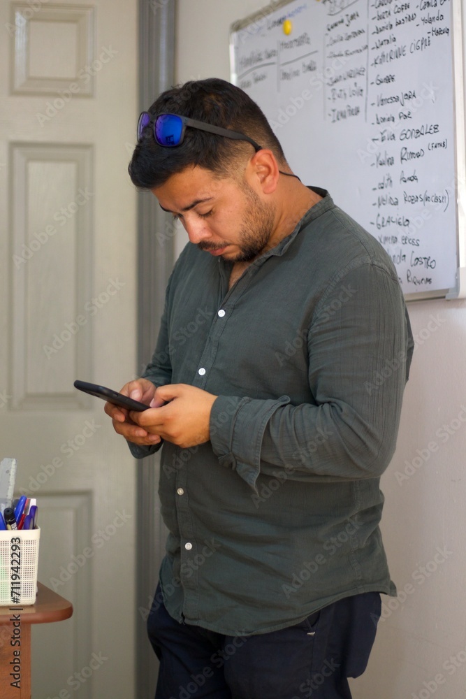 latin man checking social networks in a classroom