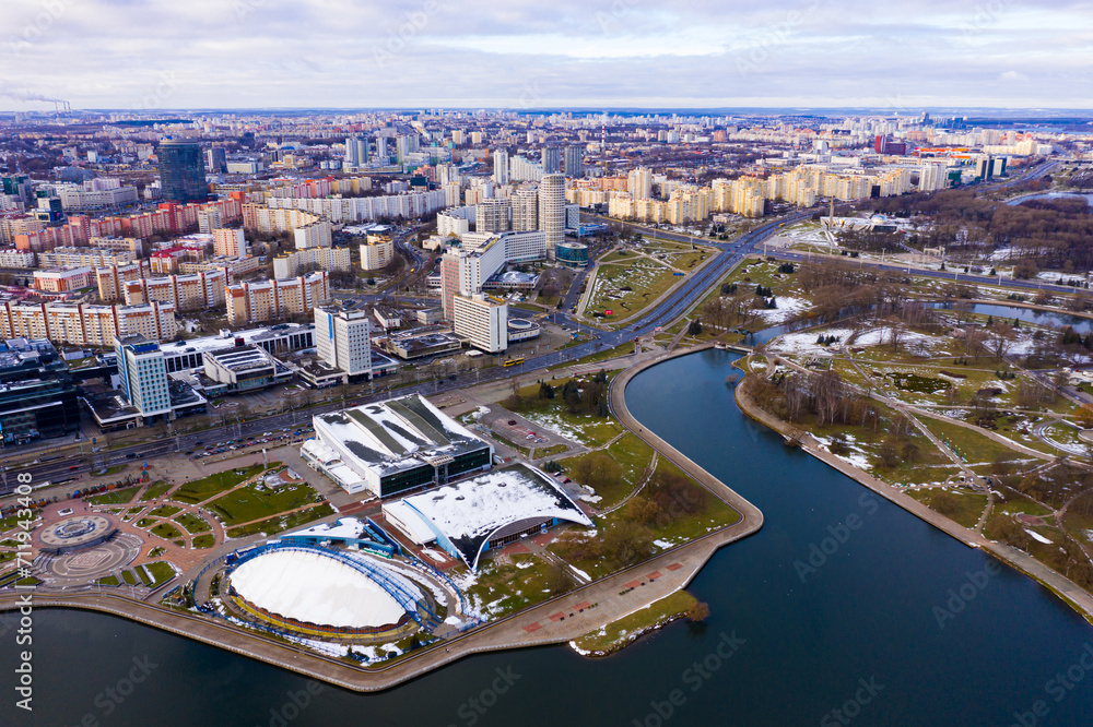 Obraz premium View from drone of downtown Minsk with modern residential neighborhoods and indoor sports arena on banks of Svislach river on winter day, Belarus..