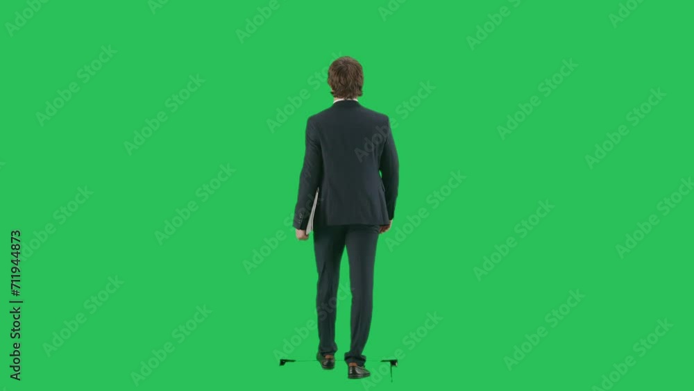 Back shot of male model in suit isolated on chroma key green screen background. Young businessman office worker in suit walking and waving hand. Back shot of male model in suit isolated on chroma key green screen background. Young businessman office worker in suit walking and waving hand.