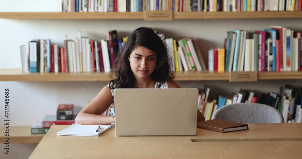 Young Indian woman studying on-line make research, e-learning looking focused sit at desk in university library. Businesswoman working on computer in office, typing e-mail, contact to client remotely Young Indian woman studying on-line make research, e-learning looking focused sit at desk in university library. Businesswoman working on computer in office, typing e-mail, contact to client remotely