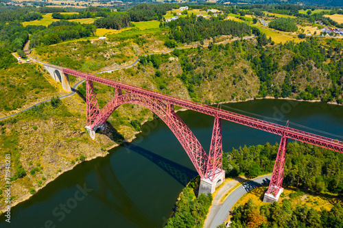 Scenic drone view of parabolic arched framework of railway bridge Viaduc de Garabit across river Truyere near Ruynes-en-Margeride in Auvergne, France..